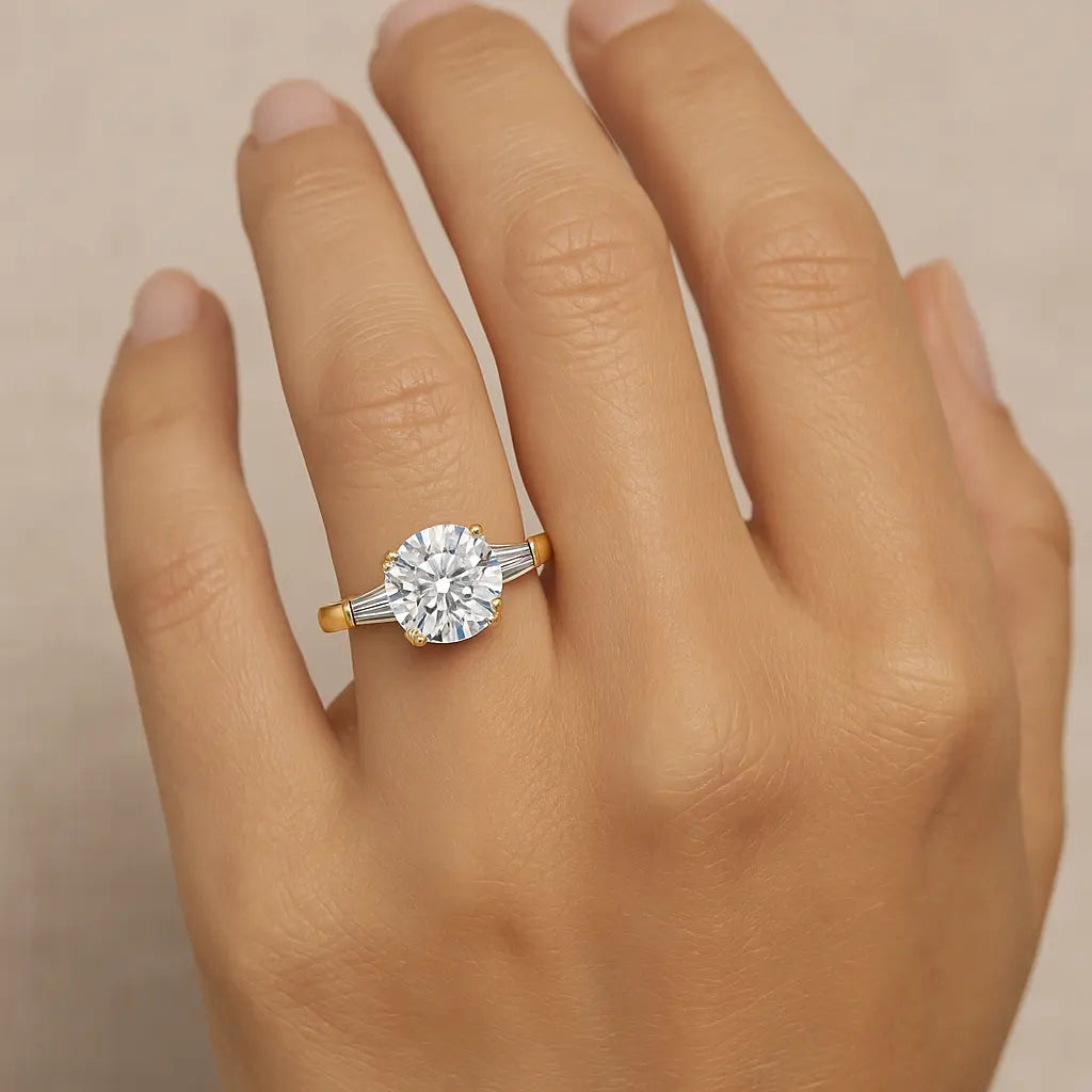 Gold and diamond ring on a hand against a beige background