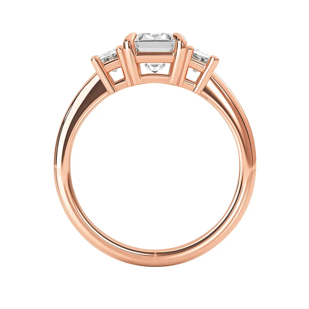 Rose gold ring with emerald cut diamond on a white background standing up