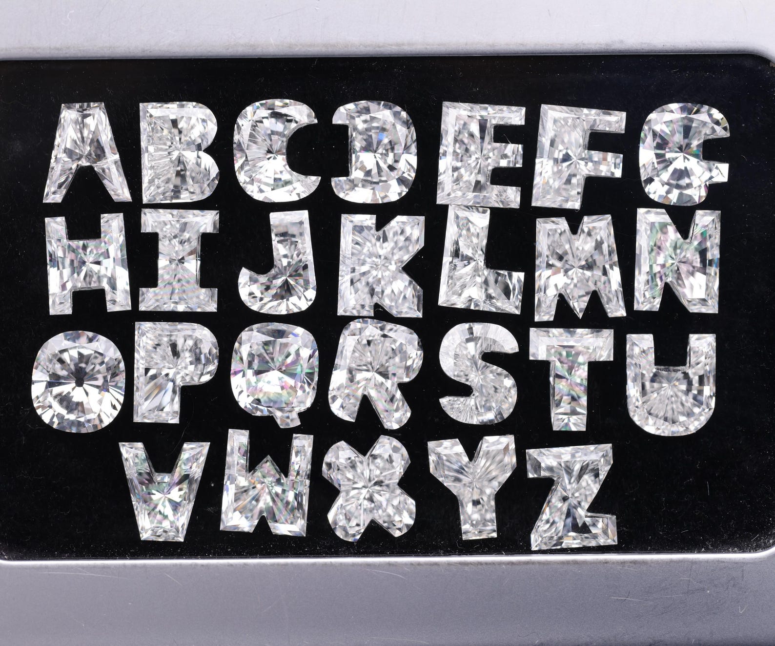 Alphabet letters crafted from custom cut lab diamonds arranged on a black background