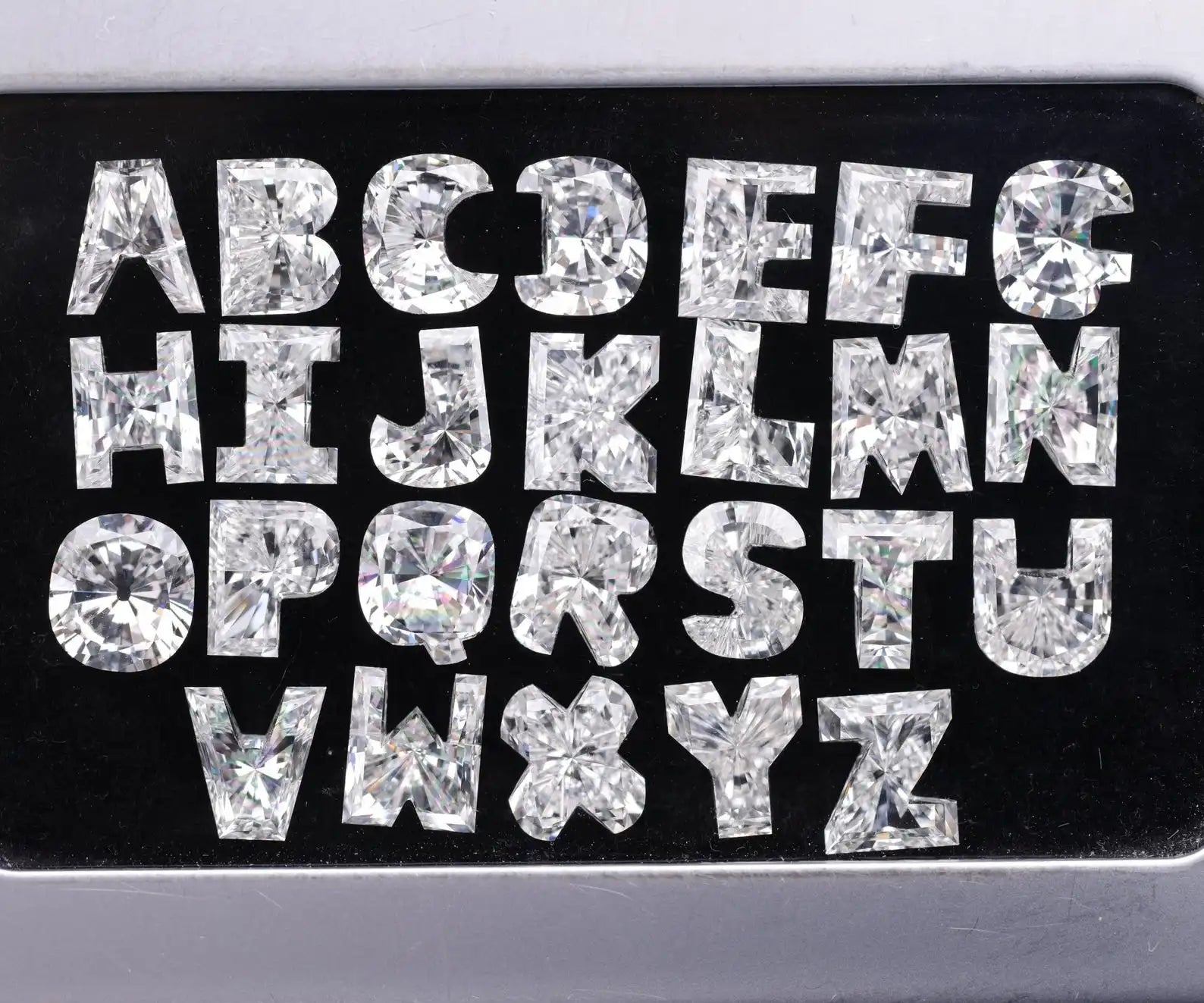 Alphabet letters crafted from custom cut lab diamonds arranged on a black background