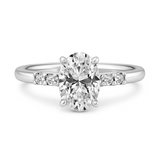 Diamond ring with a central oval-cut diamond and smaller diamonds on the sides on a white background