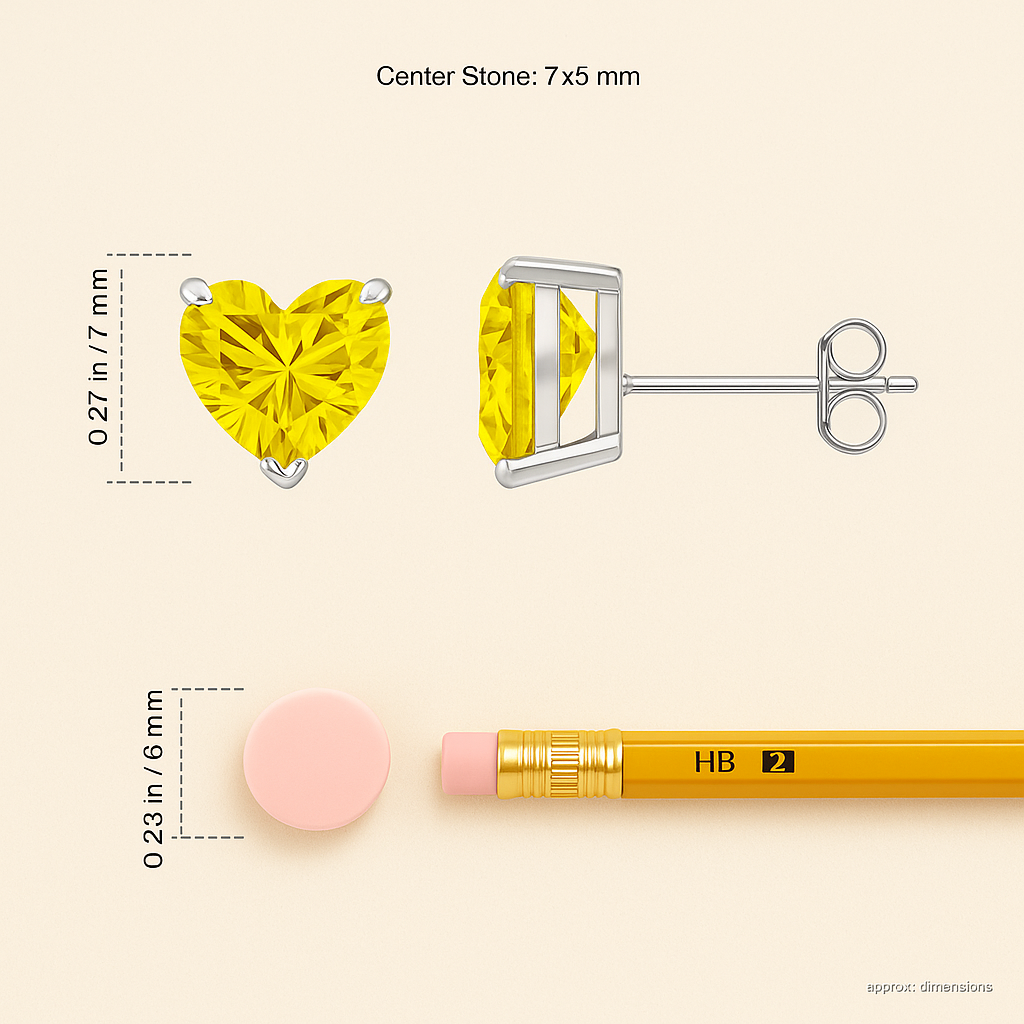Yellow gemstone earrings with heart and round cut, compared to a pencil for size reference on a beige background.